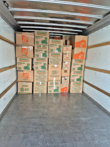 Moving boxes stacked in organized rows at the front of a moving truck