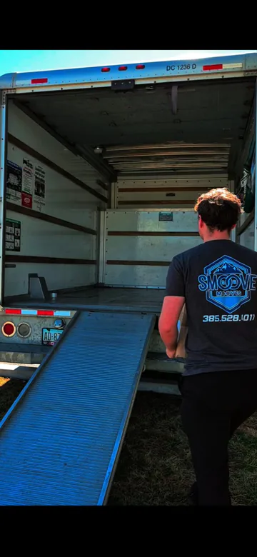 Smoove Mooves crew member standing at the ramp of a moving truck