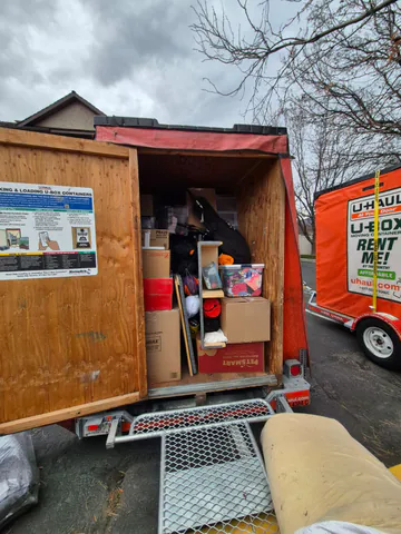 Moving container loaded with boxes, protected furniture, and household items