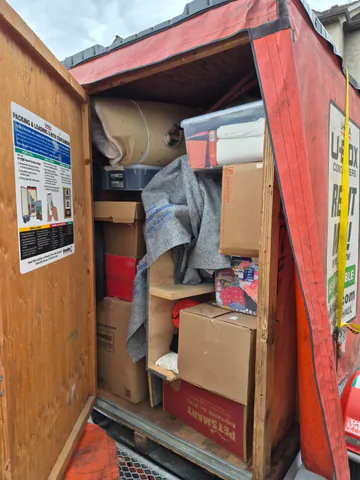Moving container packed with protected furniture, boxes, and household items