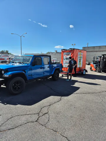 Customer vehicle connected to a moving container trailer during pickup